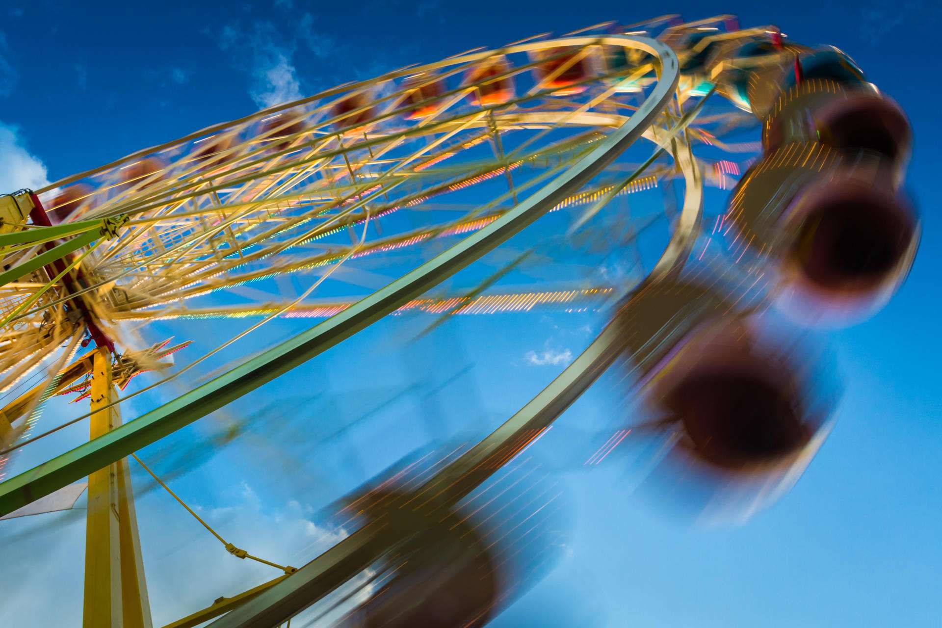 blurry-ferris-wheel-in-motion-on-blue-sky-backgrou-2025-03-24-03-53-48-utc_11zon