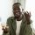 Video call concept. Happy african american man talking to camera, gesturing and smiling, sitting at workplace at home. Modern remote communication and e-teaching