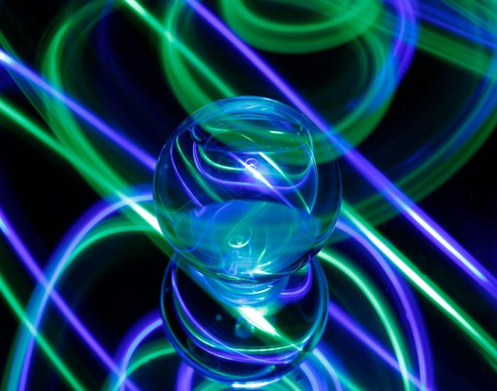 An intriguing green and blue light emanating from a light bulb in a dimly lit setting creating a mysterious aesthetic