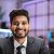 Smiling positive confident indian man in formal wear sitting at office desk. Company worker with beard looking at camera. Concept of people and business.