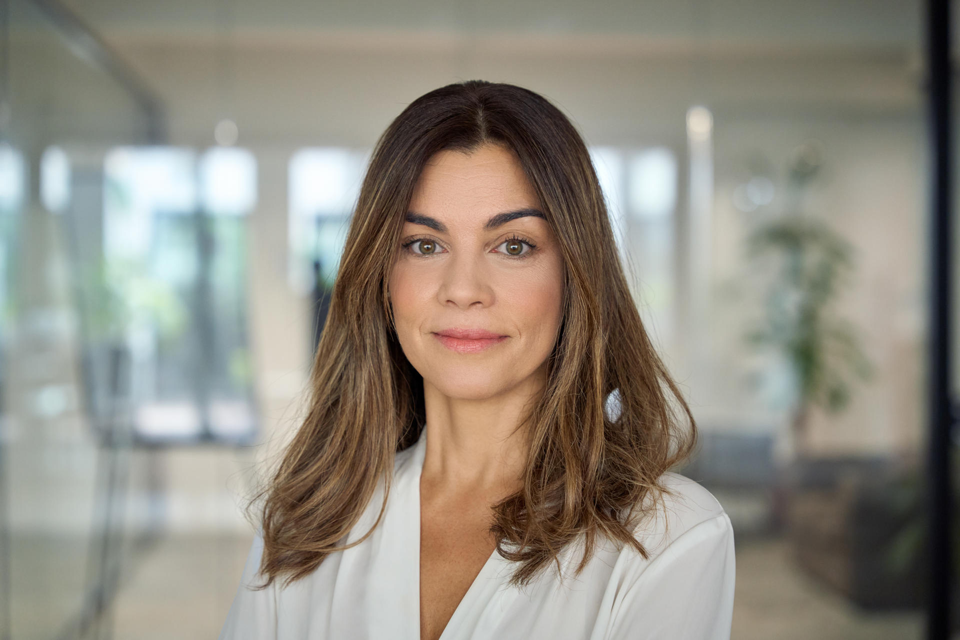 Confident smiling professional mid aged business woman in office, portrait. Confident smiling Latin professional mid aged elegant business woman corporate leader, happy beautiful mature female executive, lady manager standing in office looking at camera, headshot portrait.