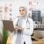 Muslim female doctor posing at hospital room with modern laptop in hands. Competent medical specialist in hijab using modern gadget for work.