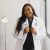 Portrait Of Smiling Female Doctor Wearing White Coat With Stethoscope In Hospital Office