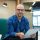 Bald Man Holding Clipboard in office Portrait of bald adult man holding clipboard with questionnaire while sitting on couch in modern office interior, copy space