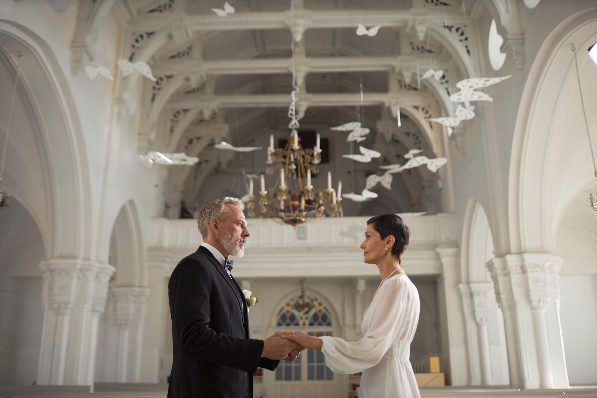 wide-angle-senior-bride-and-groom-holding-hands-in-2023-12-21-22-34-59-utc