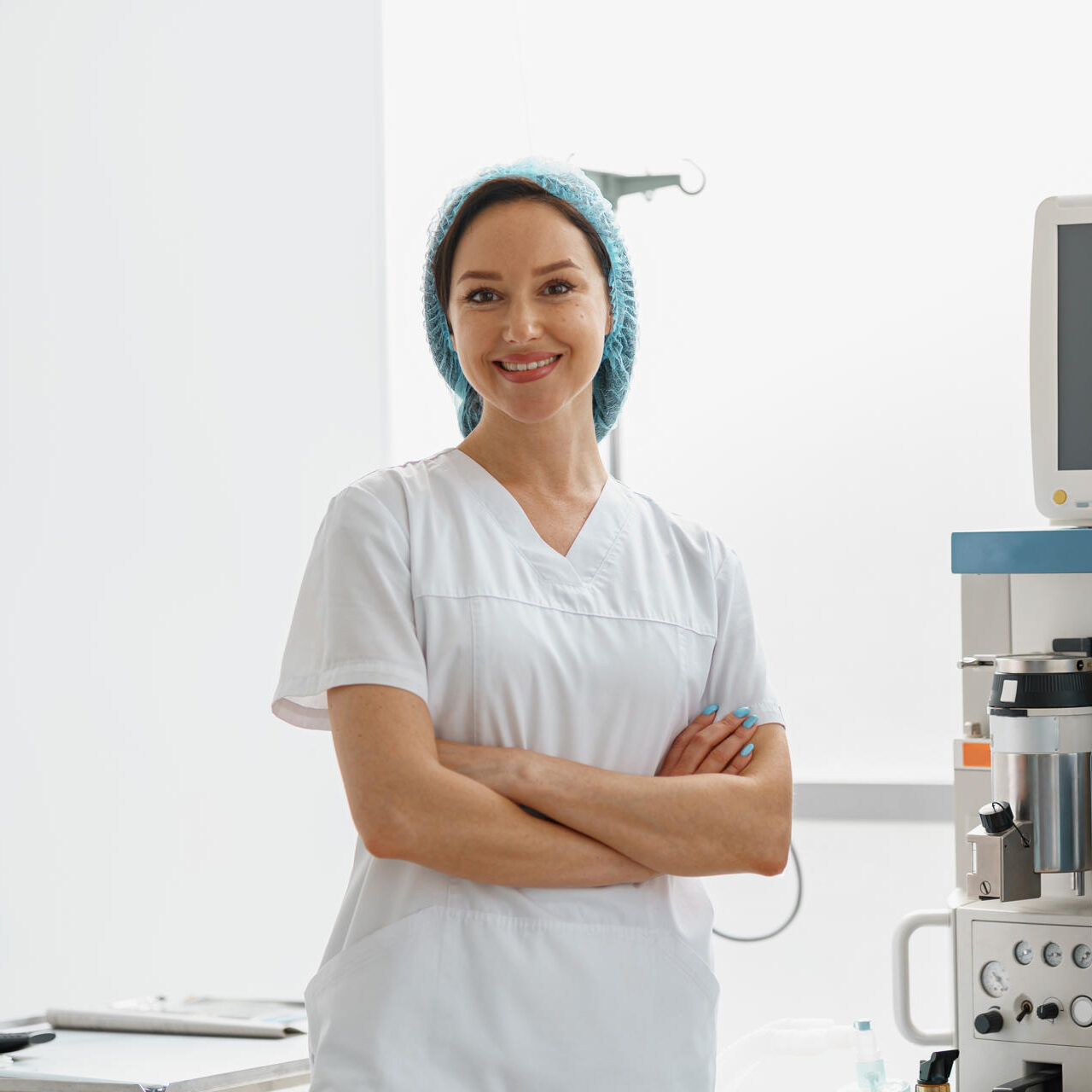Professional nurse in uniform standing in operating room on background of medical equipment Smiling nurse in uniform standing in operating room on background of medical equipment