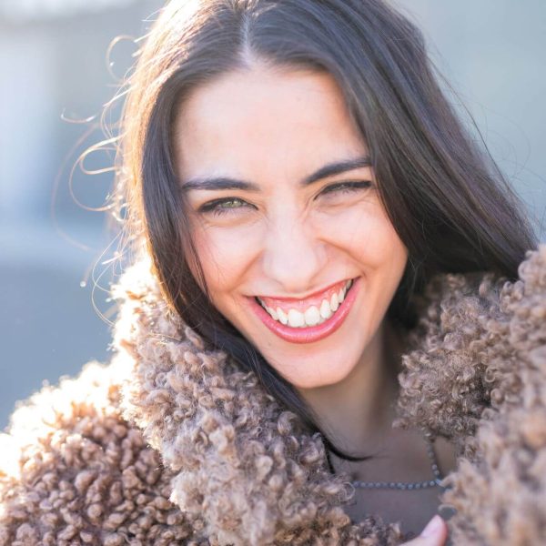 cheerful-woman-wrapping-in-coat-on-street-2023-11-27-05-34-43-utc