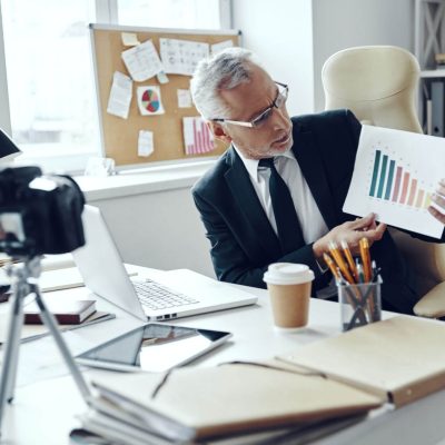 senior-man-in-elegant-business-suit-showing-chart-2023-11-27-05-16-17-utc