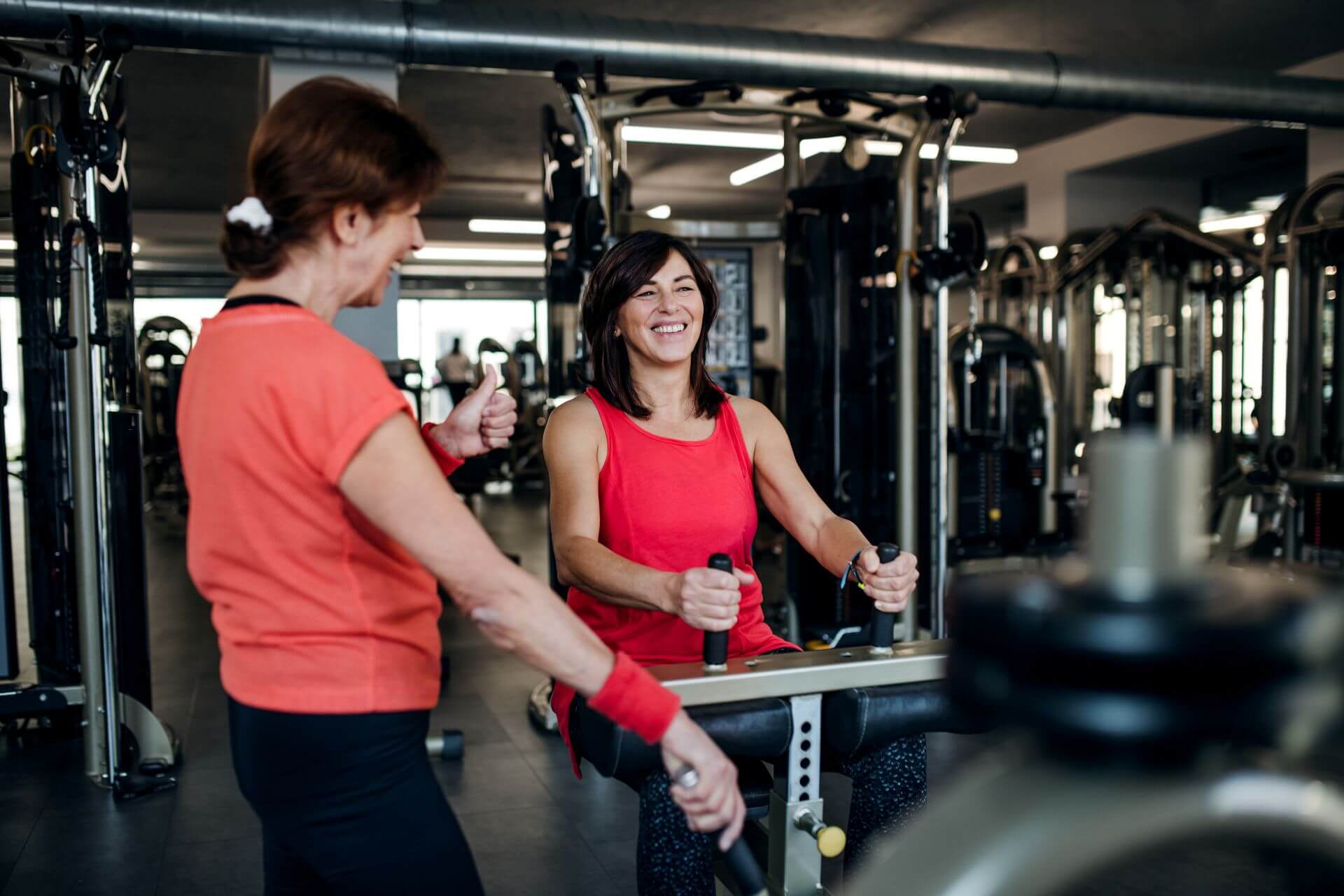 two-cheerful-senior-women-in-gym-doing-strength-wo-2024-10-18-09-31-41-utc